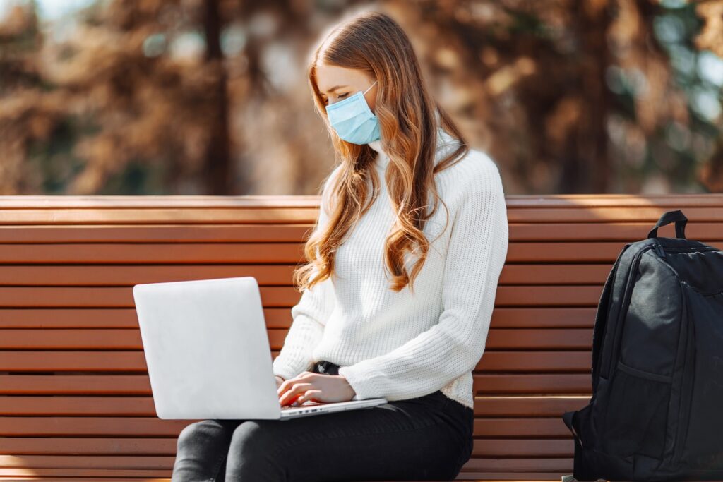 girl wearing mask on laptop