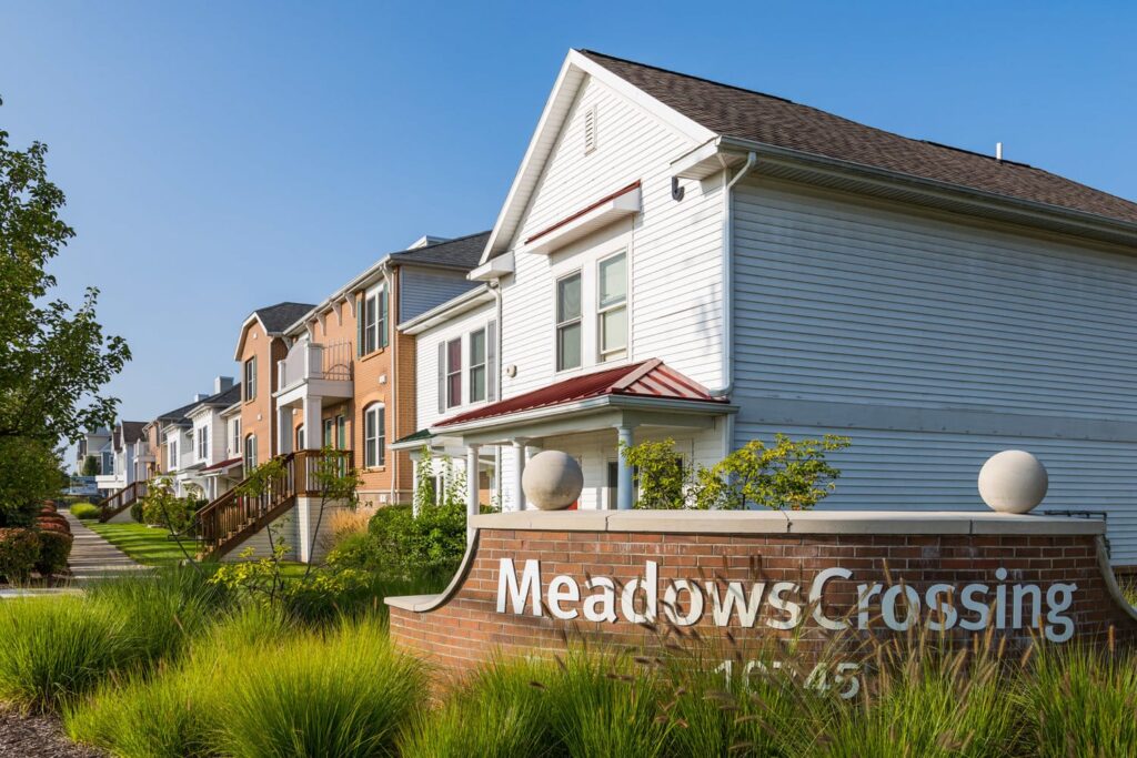 Meadows Crossing sign with townhomes behind
