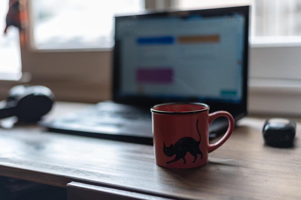 cat coffee mug in front of laptop