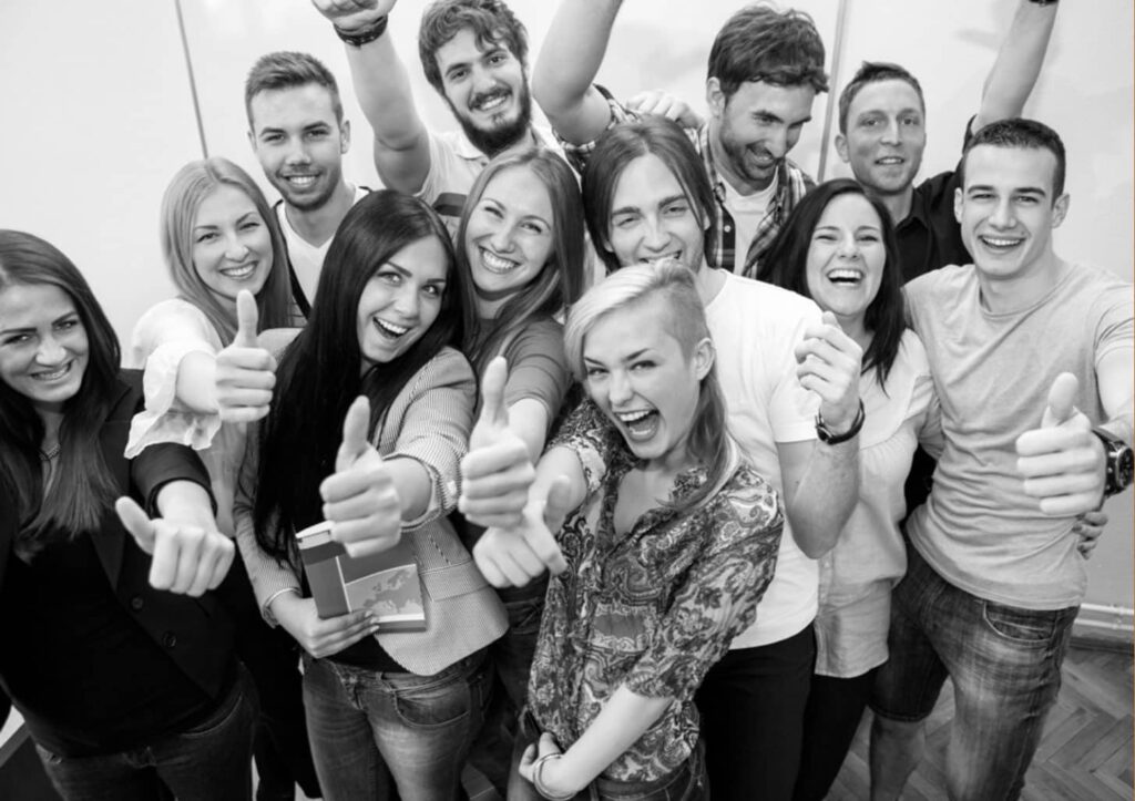 Happy young people giving thumbs up