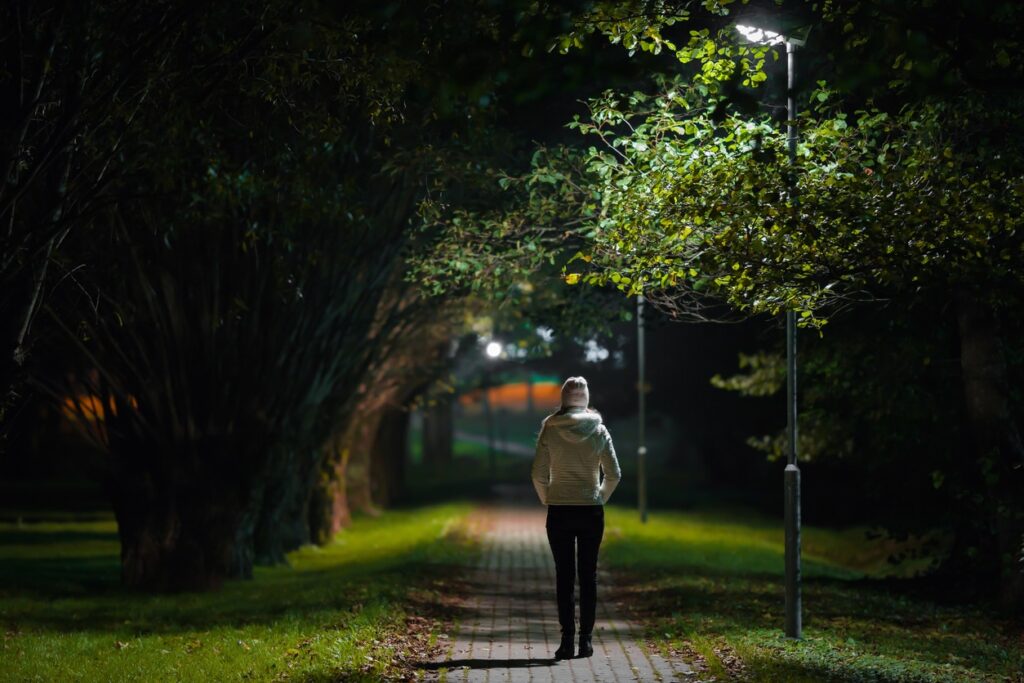 One young woman in white jacket walking at night